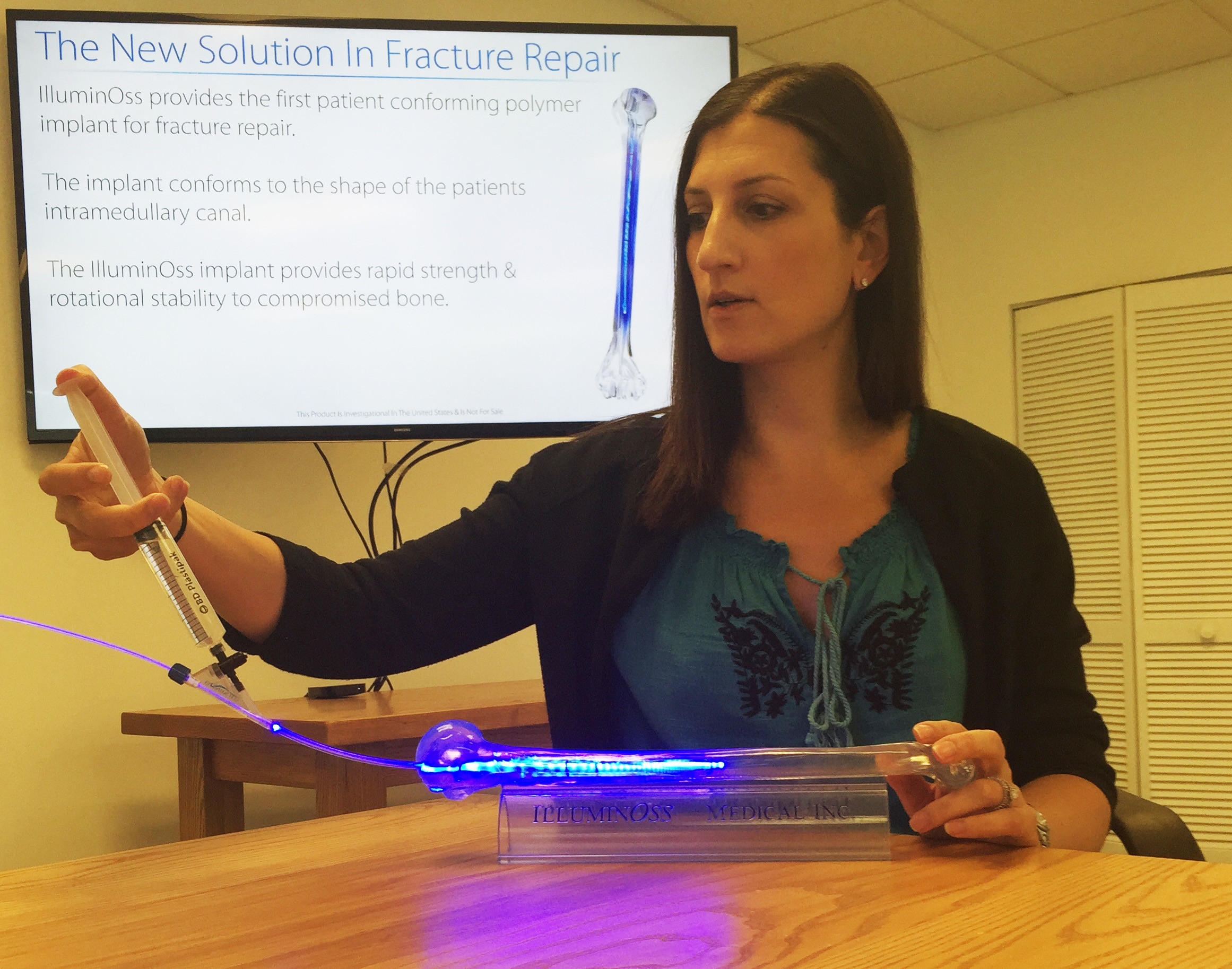 An employee demonstrates IlluminOss's new technology to repair bone fracture.